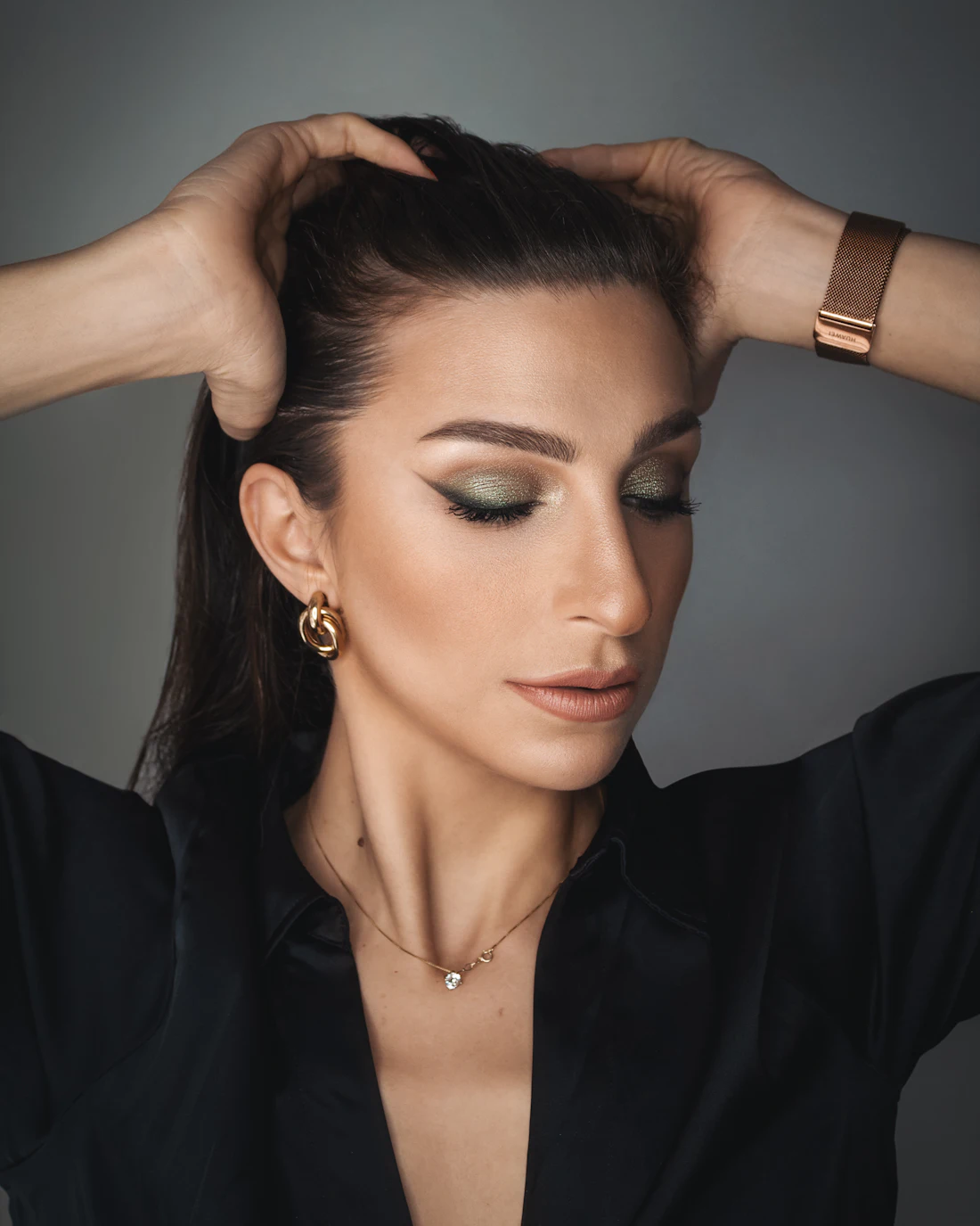 Mujer con el look terminado: seda negra y joyería dorada